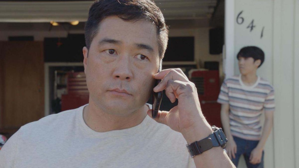 Gordon Katsumoto (Tim Kang) en pleine conversation téléphonique.