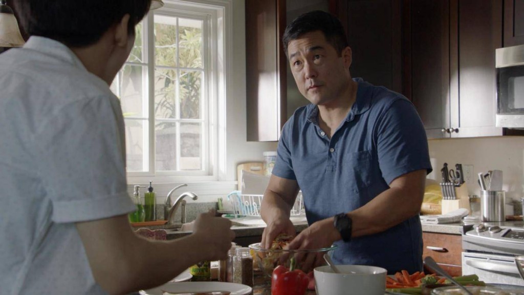 Tout en cuisinant, Gordon discute avec son fils, Dennis (Lance Lim).