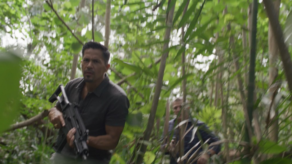 Magnum (Jay Hernandez) et Henry Sellers (Alex Carter) sont en train de courir à travers la forêt.
