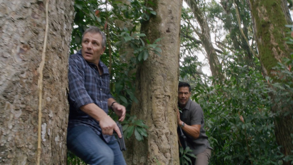 Henry Sellers (Alex Carter) et Thomas Magnum (Jay Hernandez) se cachent derrière un arbre.