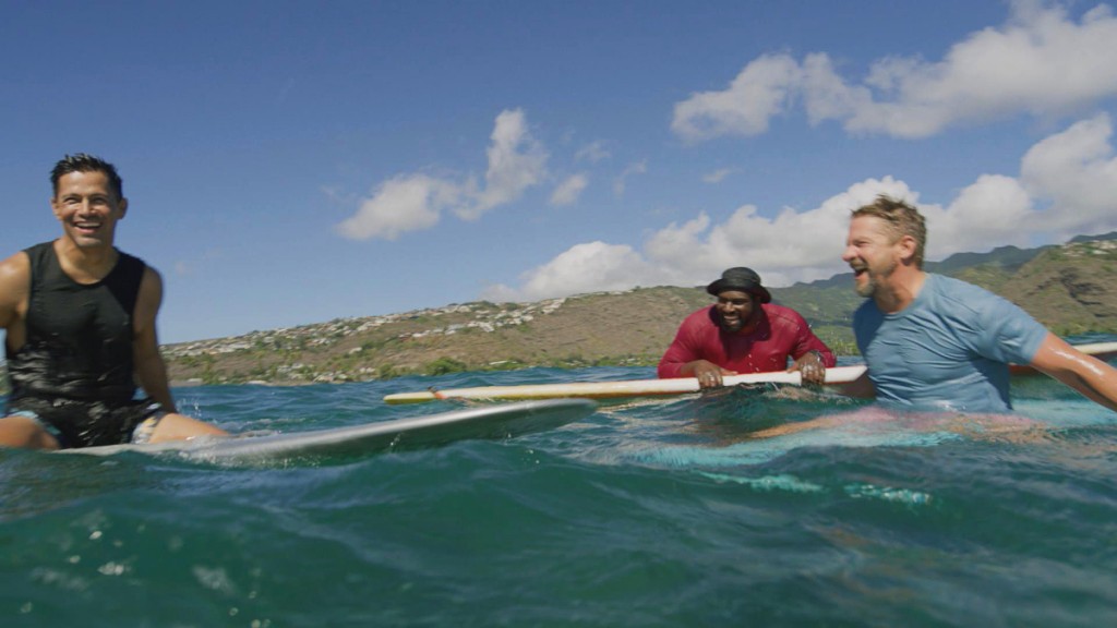 Magnum (Jay Hernandez), TC (Stephen Hill) et Rick (Zachary Knighton) sont assis sur leur planche de surf.