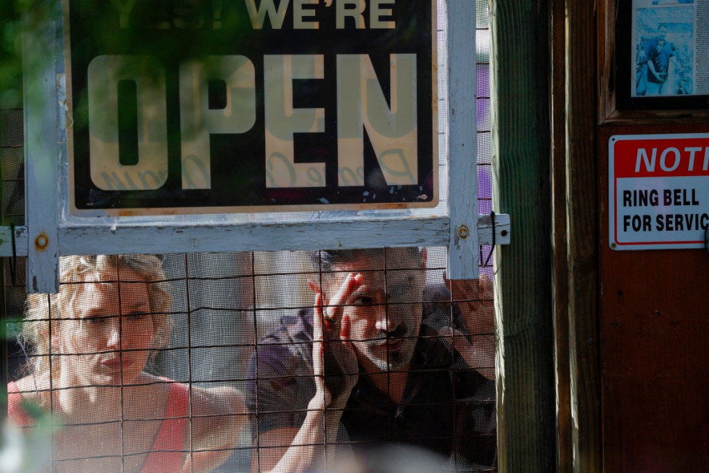 Higgins (Perdita Weeks) et Magnum (Jay Hernandez) regardent à travers la fenêtre du magasin.