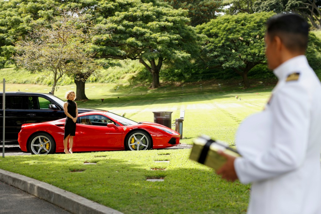 Tout en regardant Magnum (Jay Hernandez), Higgins (Perdita Weeks) attend à côté de la Ferrari.