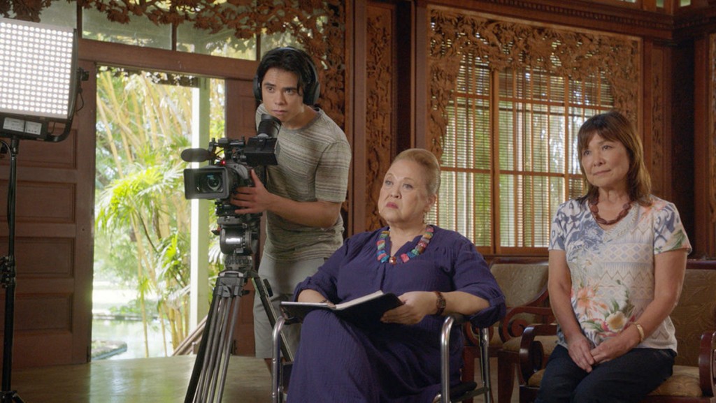 Alors que Cade (Martin Martinez) est en train de filmer, Kumu (Amy Hill) interroge quelqu'un.
